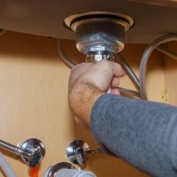 Plumber Install a Sink In kitchen of plumber repairing drain